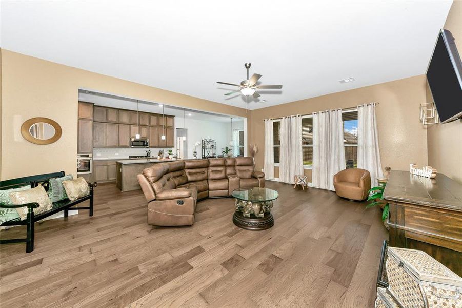 Living room with light hardwood / wood-style flooring and ceiling fan