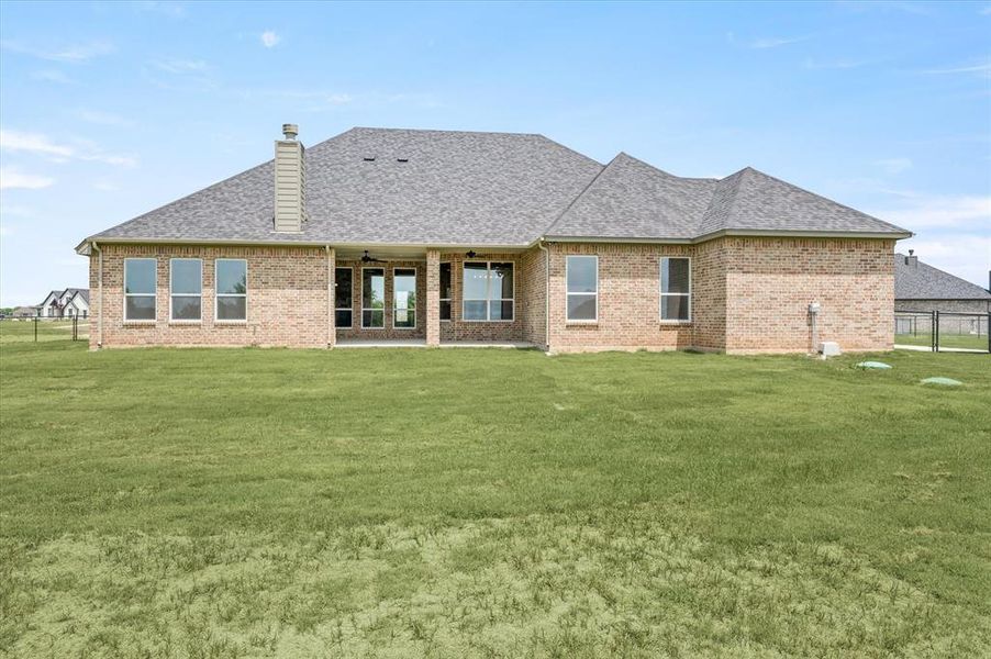 Back of property featuring a patio and a lawn