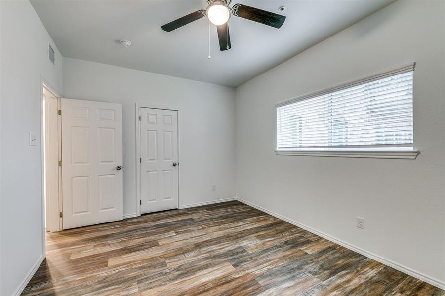 Unfurnished bedroom with ceiling fan and dark hardwood / wood-style flooring