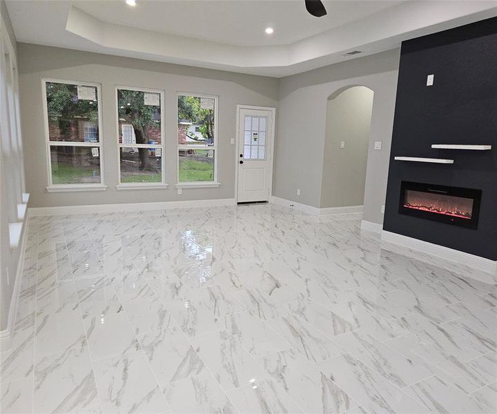 Open Living room with ceiling fan and a raised ceiling