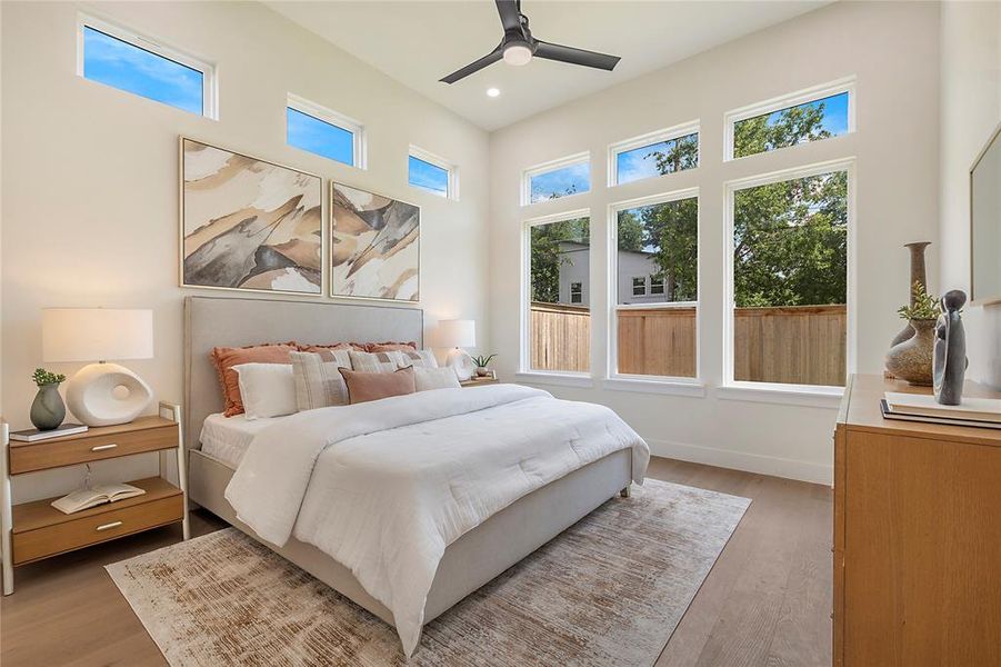 Bedroom featuring multiple windows, ceiling fan, and hardwood / wood-style floors