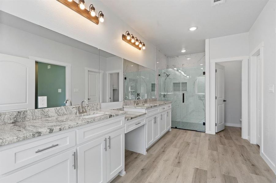 Bathroom with a shower with door, vanity, and hardwood / wood-style flooring