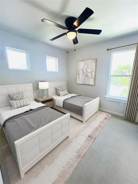 Bedroom featuring light carpet, multiple windows, and ceiling fan