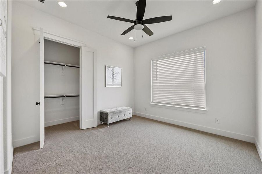 Unfurnished bedroom with light carpet and ceiling fan