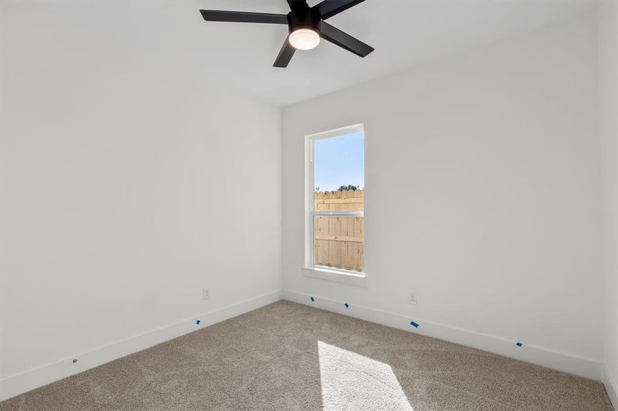 Carpeted spare room with ceiling fan