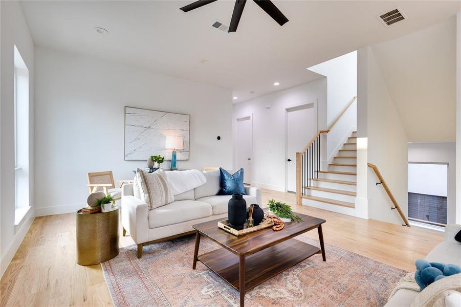 Living room with light hardwood / wood-style flooring and ceiling fan