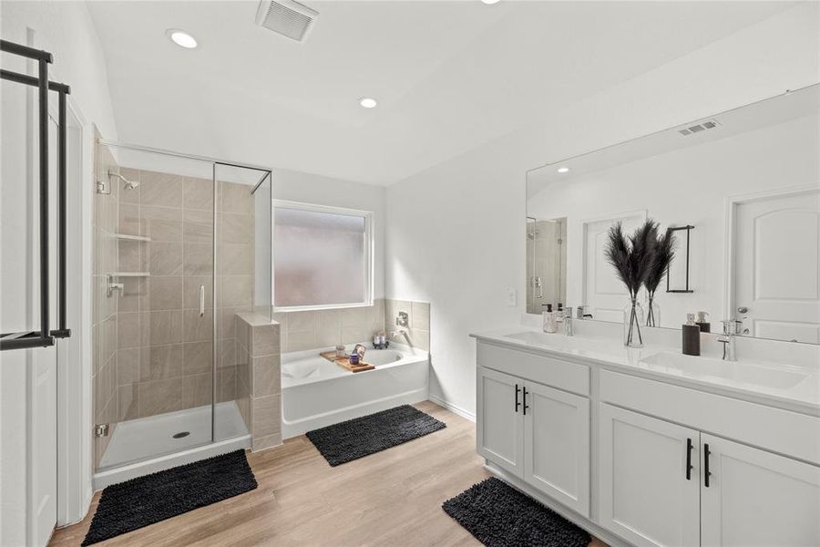 The primary bath offers dual vanities with plenty of storage. There is so much space to get ready here.