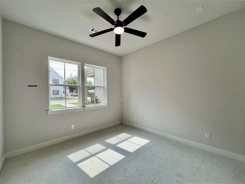 Carpeted spare room featuring ceiling fan