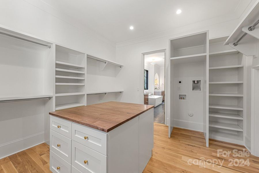 Large primary closet with island and washer/dryer hookups