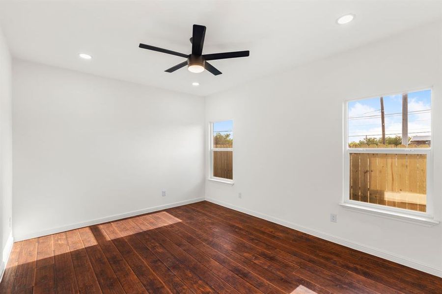 Spare room with ceiling fan, hardwood / wood-style flooring, and a wealth of natural light