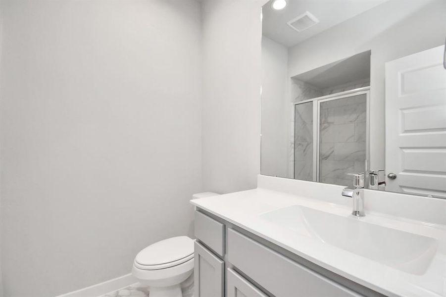 Full Guest suite bath with walk in shower. Sample photo of completed home with similar floor plan. As-built interior colors and selections may vary