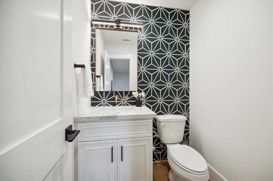 The second floor powder bath for game room/media room use features a stunning tiled wall.
