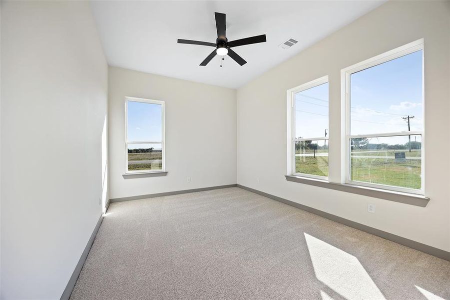 Empty room featuring light carpet and ceiling fan