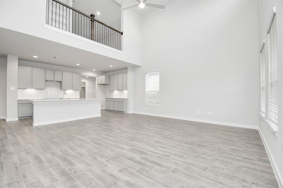 Bring your loved ones and guests together in the inviting living room! Boasting lofty high ceilings, recessed lighting, a stylish ceiling fan, custom paint, stunning flooring, and expansive windows that flood the space with ample natural light all day long.