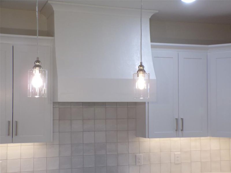 Details featuring backsplash and white cabinetry