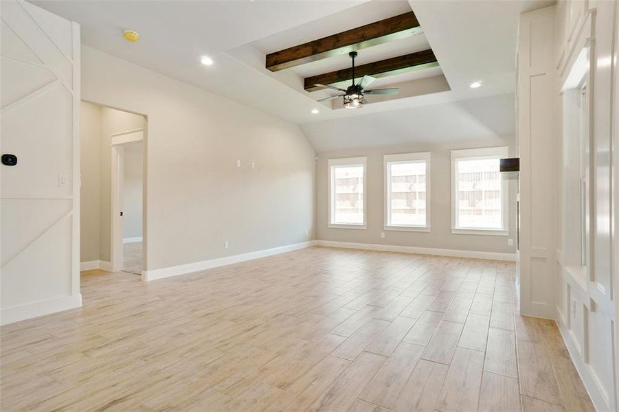 Unfurnished living room with beam ceiling, light wood-type flooring, and ceiling fan