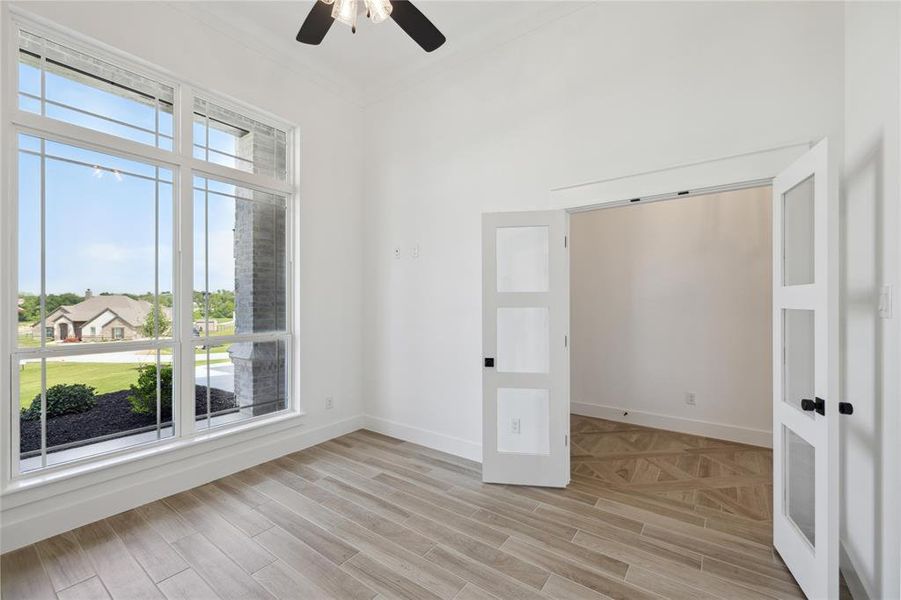 Spare room with light wood-type flooring, ornamental molding, and ceiling fan