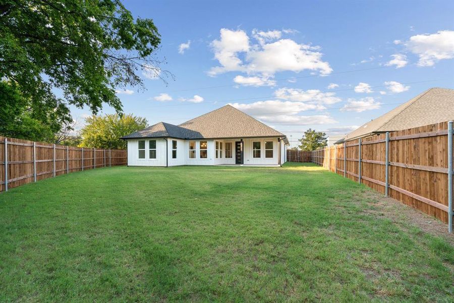 Back of property featuring a lawn