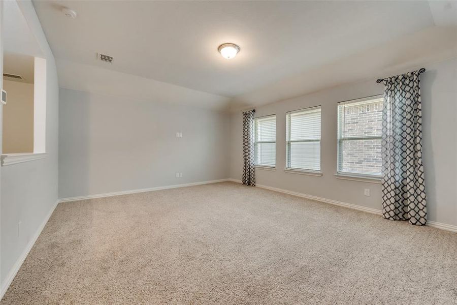 Unfurnished room with vaulted ceiling and carpet