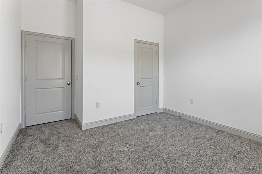 Unfurnished bedroom with light colored carpet