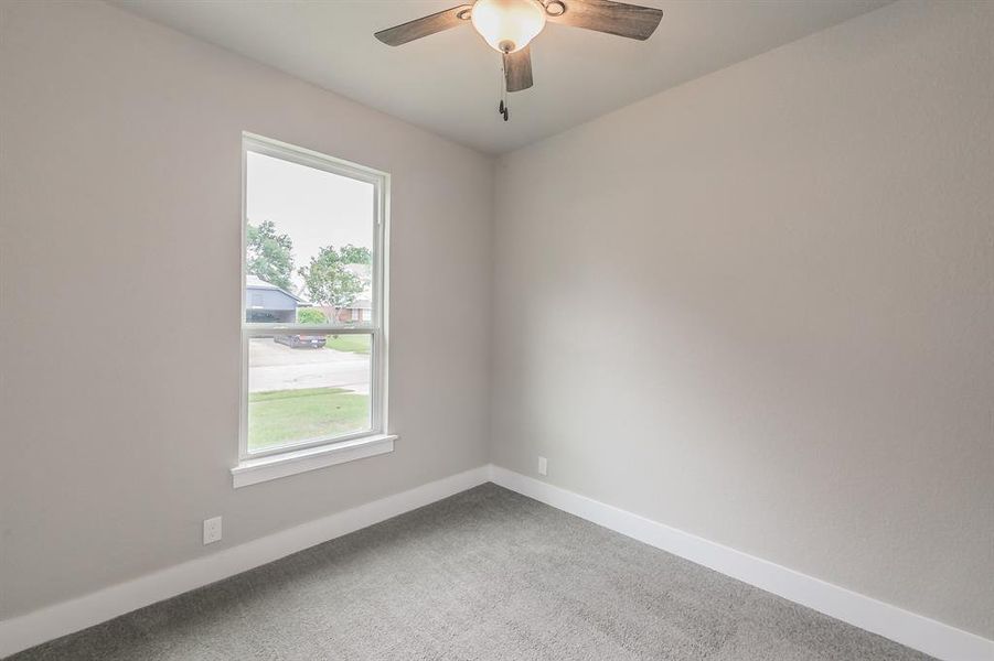 Carpeted spare room with ceiling fan