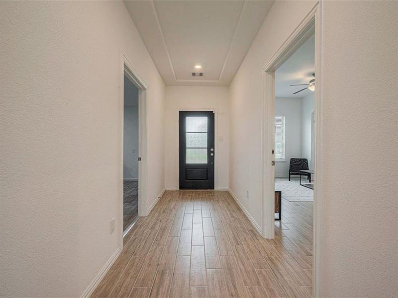 The well-lit hallway creates a bright and inviting entrance.