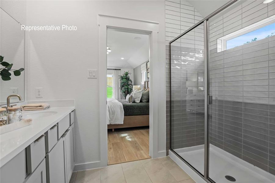 Bathroom featuring a wealth of natural light, a shower with shower door, vanity, and hardwood / wood-style flooring