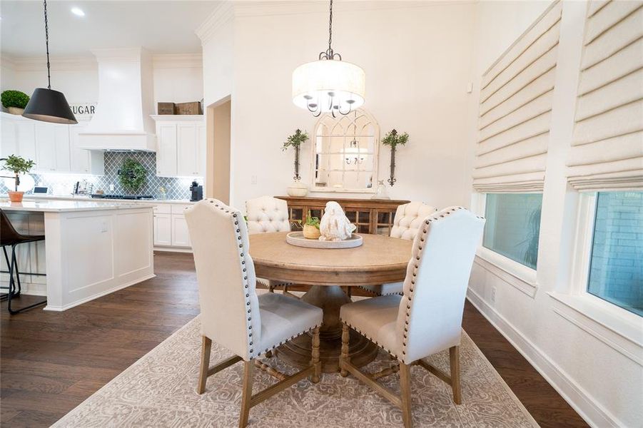 Dining space featuring ornamental molding, a chandelier, and dark hardwood / wood-style flooring