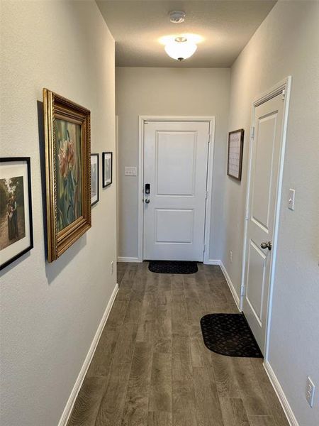 Doorway to outside with a textured ceiling and dark hardwood / wood-style flooring