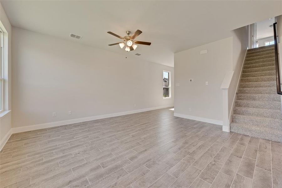 Unfurnished living room featuring light wood-type flooring and ceiling fan