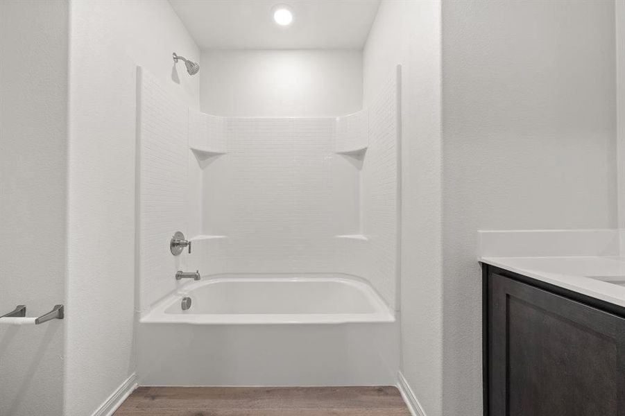 Bathroom featuring vanity, shower / washtub combination, and wood-style flooring