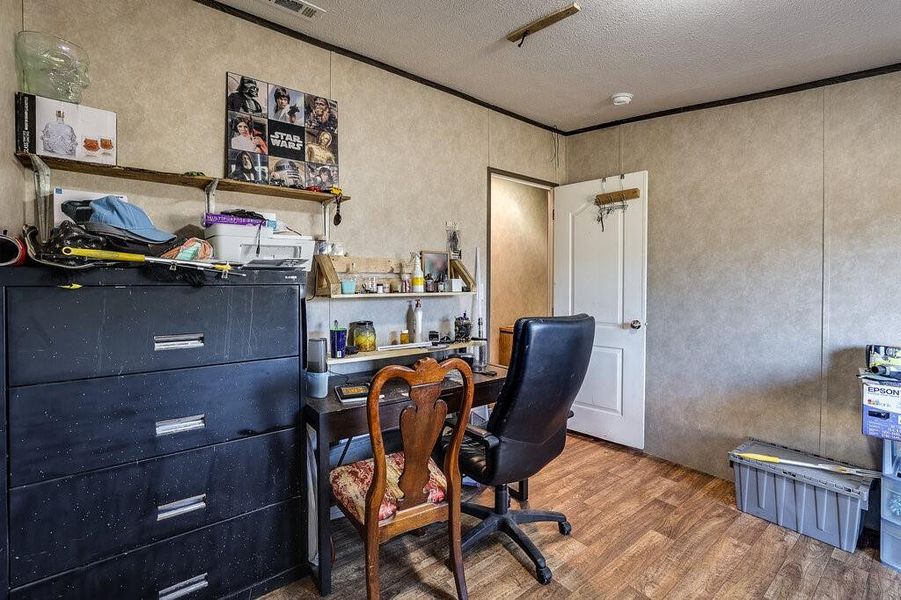 Office with wood-type flooring and a textured ceiling