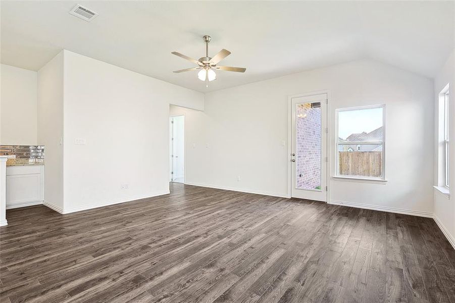 Unfurnished living room with lofted ceiling, ceiling fan, and dark hardwood / wood-style floors