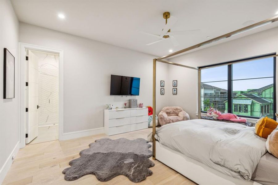 Bedroom with ceiling fan, light hardwood / wood-style floors, and ensuite bathroom