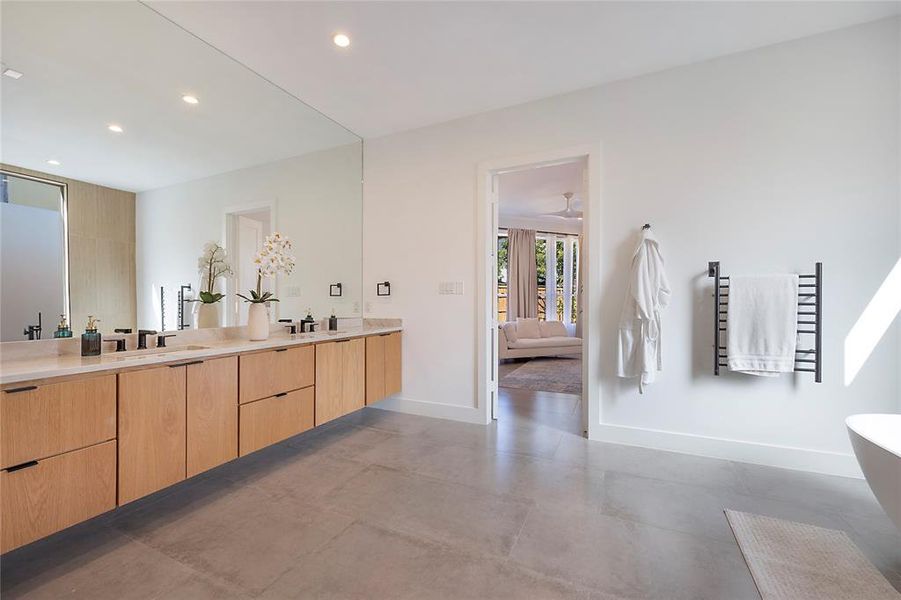 Bathroom featuring vanity, concrete floors, and a bathing tub