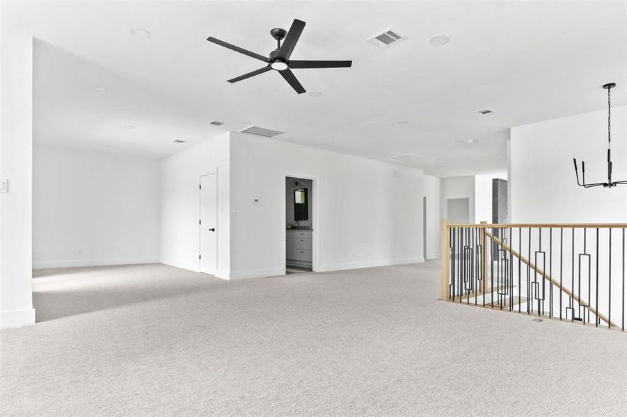 Unfurnished living room featuring ceiling fan and light colored carpet