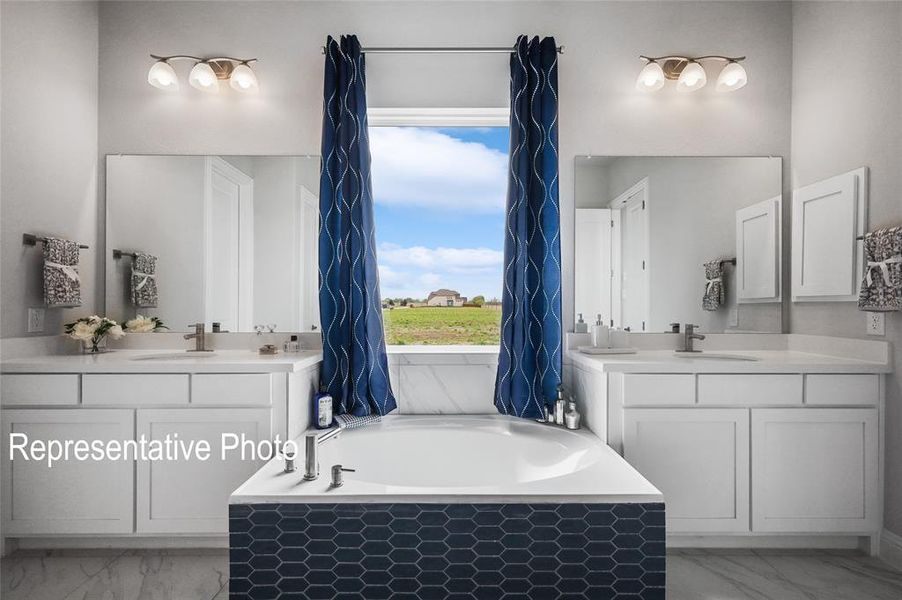Bathroom featuring dual vanity, tile flooring, and a bathing tub