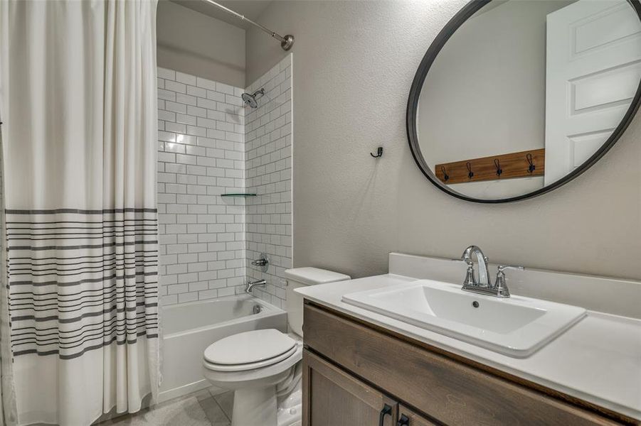 Full bathroom featuring shower / tub combo with curtain, vanity, and toilet