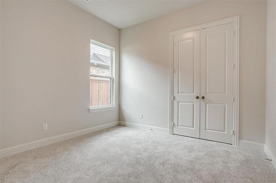 Unfurnished bedroom featuring light carpet and a closet