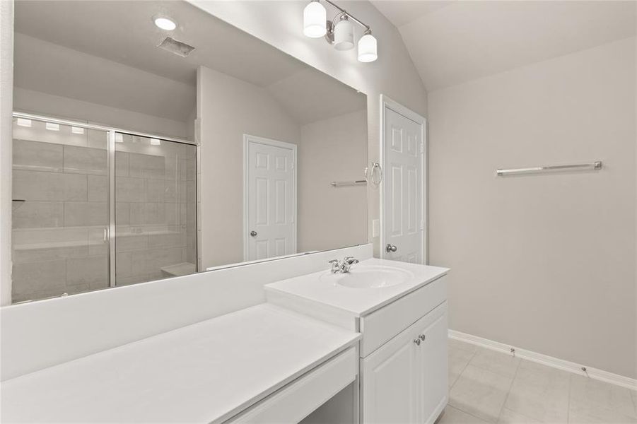 The secondary bath features tile flooring, white cabinetry and light countertops and a shower/tub combo. Perfect for accommodating any visiting family and friends.