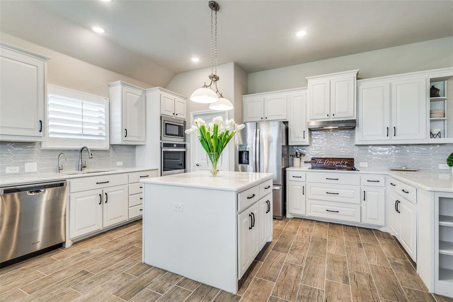 Kitchen with sink, a center island, decorative backsplash, and stainless steel appliances