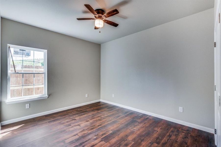 Spare room featuring ceiling fan and dark hardwood / wood-style flooring