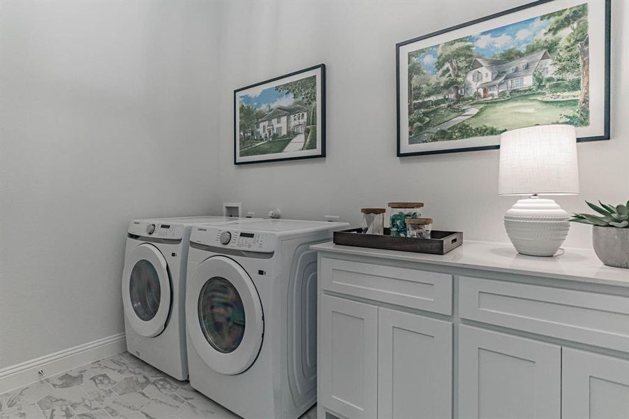Laundry room with cabinets, washer hookup, light tile floors, and washing machine and clothes dryer