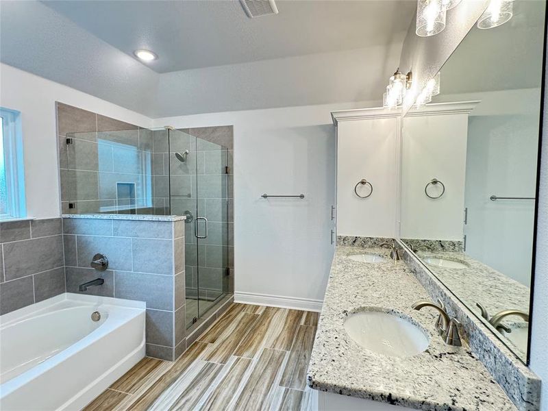 Bathroom featuring plus walk in shower, tile patterned floors, and double vanity