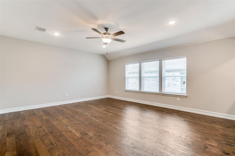 Spare room featuring vaulted ceiling, ceiling fan, and dark hardwood / wood-style floors