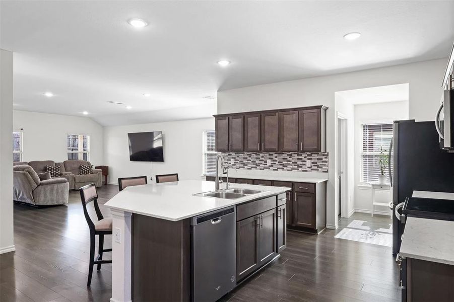 Kitchen featuring sink, stainless steel appliances, dark hardwood / wood-style floors, a kitchen island with sink, and dark brown cabinets