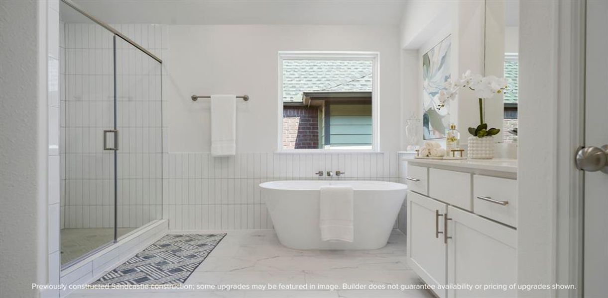 Ensuite Elegance: Step into the primary suite's ensuite bathroom, boasting abundant space and luxurious finishes, including a spa-like shower adjacent to the elegant freestanding tub.