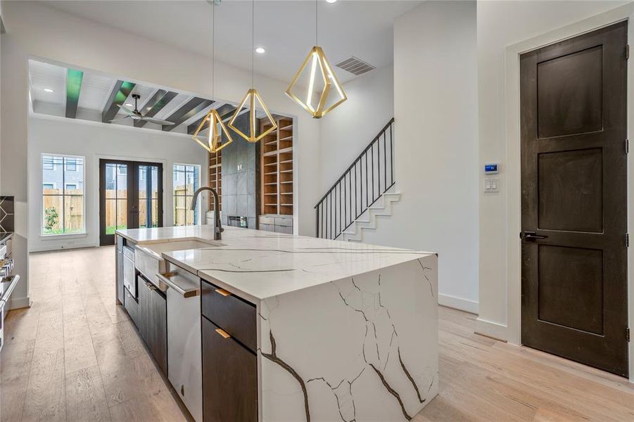 Waterfall island with custom pendant lighting is where you will gather with friends and family to enjoy this beautiful home. Closed door to the right is your large walk-in pantry.