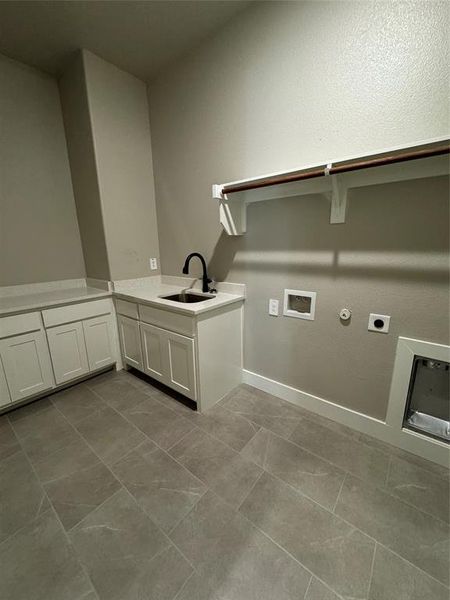 Laundry room with hookup for a washing machine, hookup for a gas dryer, electric dryer hookup, cabinets, and sink