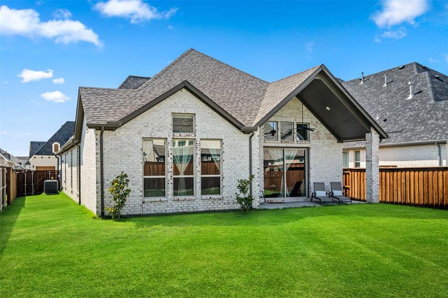 Back of property featuring a patio, central AC, and a yard